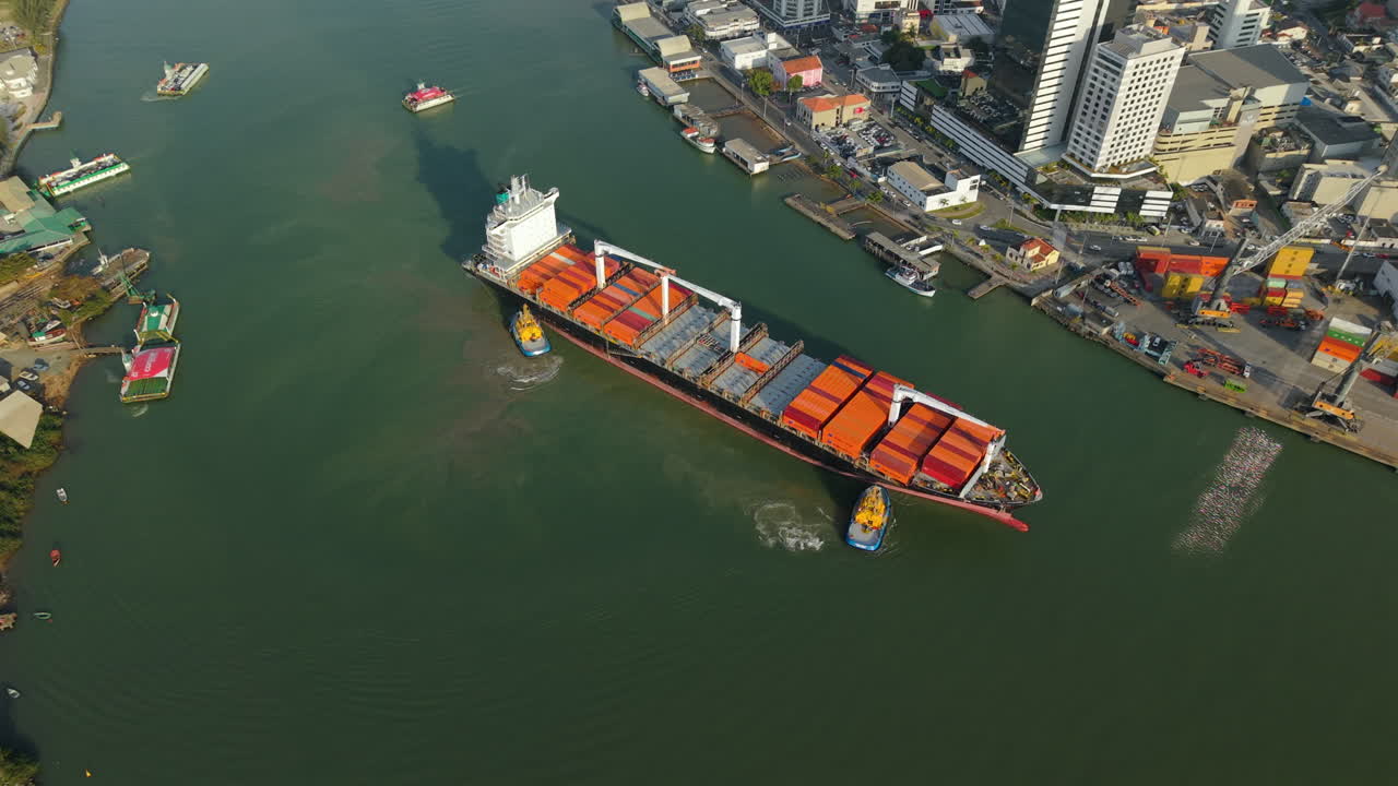 Top-down aerial view of industrial container ship docking and unloading cargo, Itajaí port, Santa Catarina, Brazil
