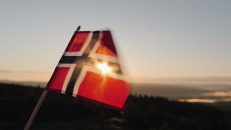 la bandera de noruega ondea al viento el sol brilla maravillosamente a través de la tela en la parte superior de