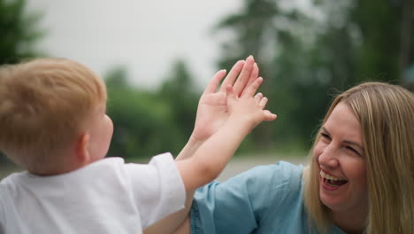 close-up of a mother sharing a fun, joyful moment with her two young boys, giving them a high five