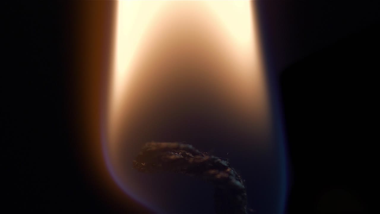 primer plano de una mecha de vela en llamas