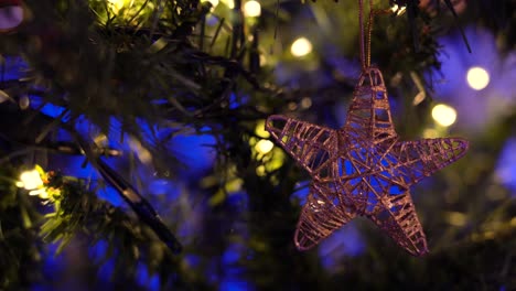 juguete en forma de estrella colgado en la rama del árbol de navidad