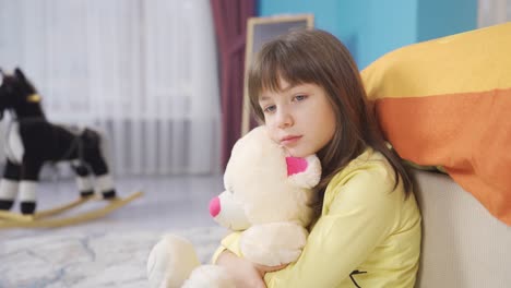 Gelangweiltes,-Unglückliches-Kleines-Mädchen,-Das-Ihren-Teddybären-In-Ihrem-Zimmer-Umarmt.