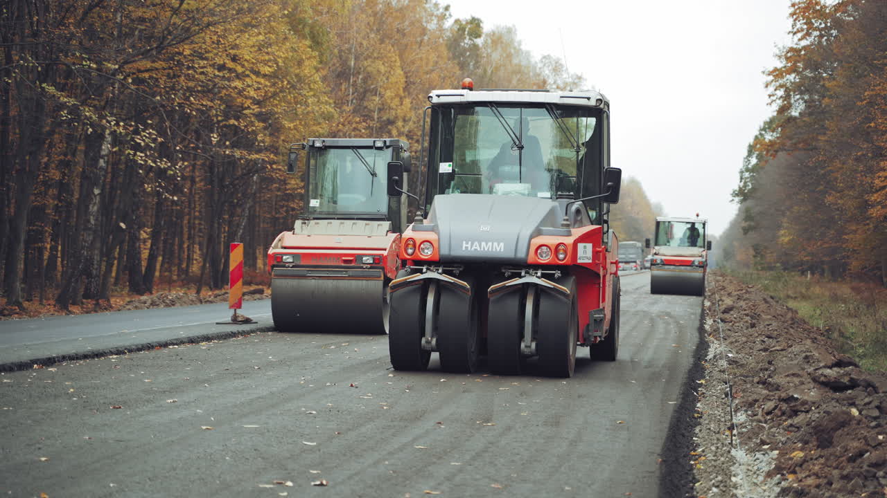Construction and repair of roads. Group of compactors and heavy vibration rollers at asphalt pavement works