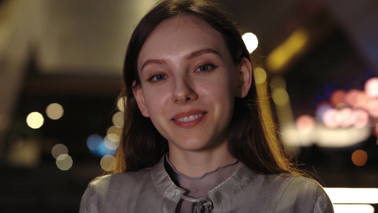 Beautiful Young Woman Turns and Smiles at Camera