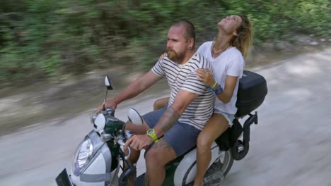 happy couple enjoying road trip on scooter