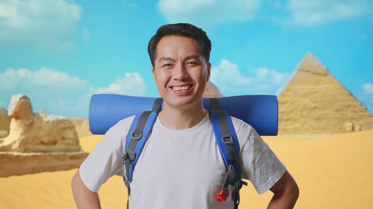 Close Up Of Asian Male Hiker With Mountaineering Backpack Smiling And Posing Arms Akimbo While Traveling In Pyramid Of Giza