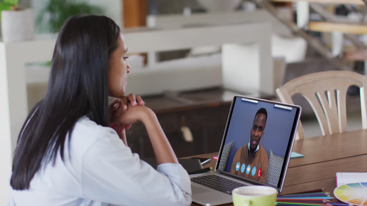 Caucasian woman using laptop on video call with male colleague working from home