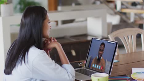 mujer caucásica usando una computadora portátil en una videollamada con un colega que trabaja desde casa
