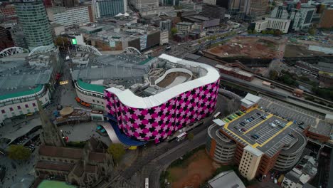 push in aerial shot over the famous landmark of the bull ring shopping mall in birmingham england