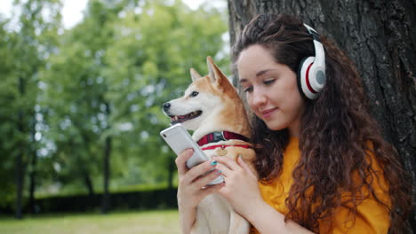 woman with headphones and dog in park