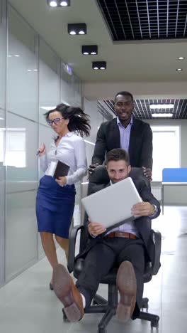 team pushing a colleague in an office