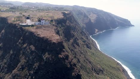 Toma-De-Seguimiento-Aéreo-Del-Faro-De-Madeira-Ponto-Da-Pargo-De-Izquierda-A-Derecha-Sobre-El-Mar.