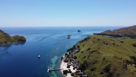 pulau sebayur island komodo resort in indonesia with boats and huts near the main pier, aerial dolly out reveal shot