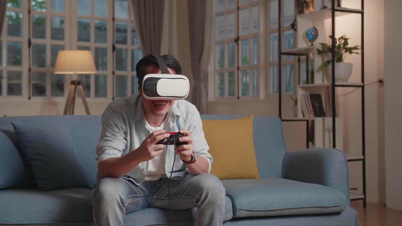 Giovane gamer maschio eccitato che gioca a un videogioco a casa indossando visori VR.