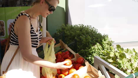 una mujer joven comprando verduras frescas.