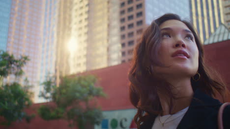 Closeup-cute-woman-look-back-on-city-building.-Portrait-asian-girl-on-sunlight.