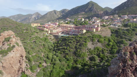 Aerial-view-passing-between-two-rock-formations-located-in-the-city-of-Nebida,-Sardinia