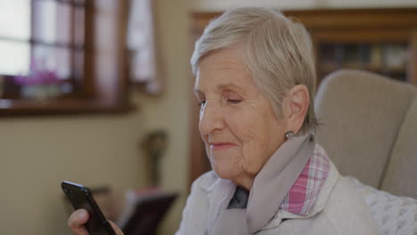 retrato de una anciana feliz usando un teléfono inteligente enviando mensajes de texto navegando bebiendo café disfrutando de un estilo de vida de jubilación relajado en casa