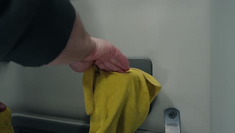 Close-up-shot-of-a-male-hand,-cleaning-a-truck-door-handle-with-a-yellow-cloth