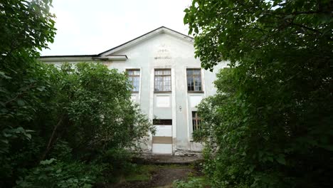 Smooth-slowmotion-shot-of-white-abandoned-house-with-old-text-on-it