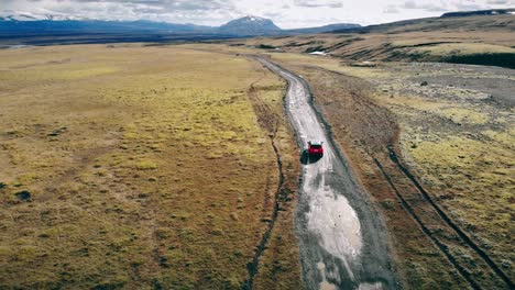 red car driving through iceland.