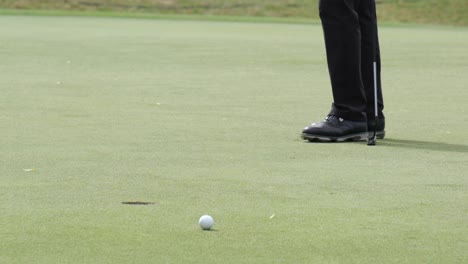 golfer failed putting golf ball to hole on green golf course on hills in open tournament competition. slow motion.