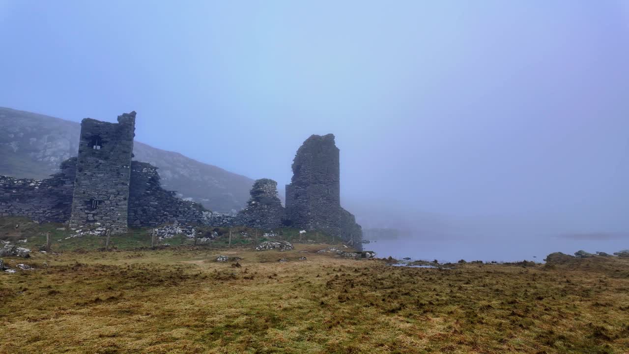 Castle in the gloom 3Castles Head Mizen West Cork imposing ruins next to a lake near the fantasy landscape in winter