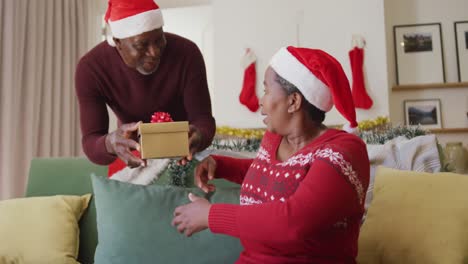 Happy-senior-african-american-man-giving-gift-to-his-wife