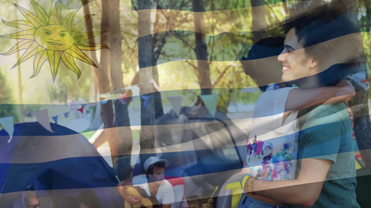 Embracing couple in forest with Uruguay flag animation and sun symbol overlay