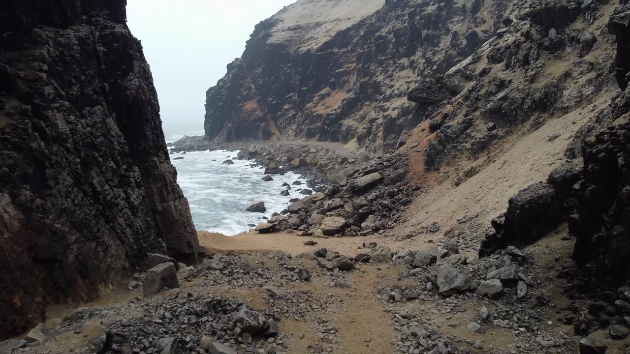 video de drones de un barranco o desfiladero junto a una playa rocosa