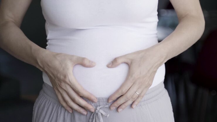 Closeup shot of pregnant woman massaging belly