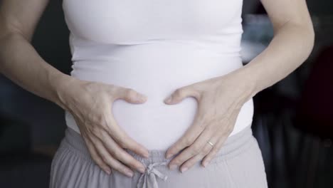 closeup shot of pregnant woman massaging belly