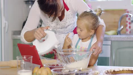 madre y hija horneando una tarta de bayas juntos