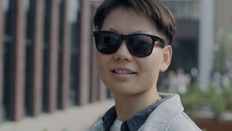smiling person with sunglasses in urban setting