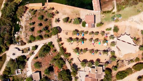 amazing-aerial-of-camp-grounds-and-people-walking,-desolate-land