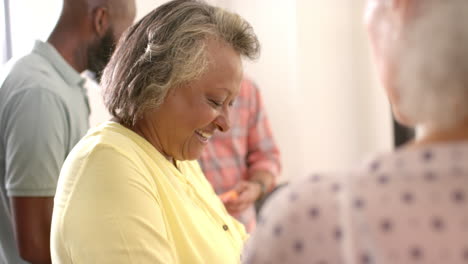 smiling senior woman enjoying time with friends at social gathering indoors