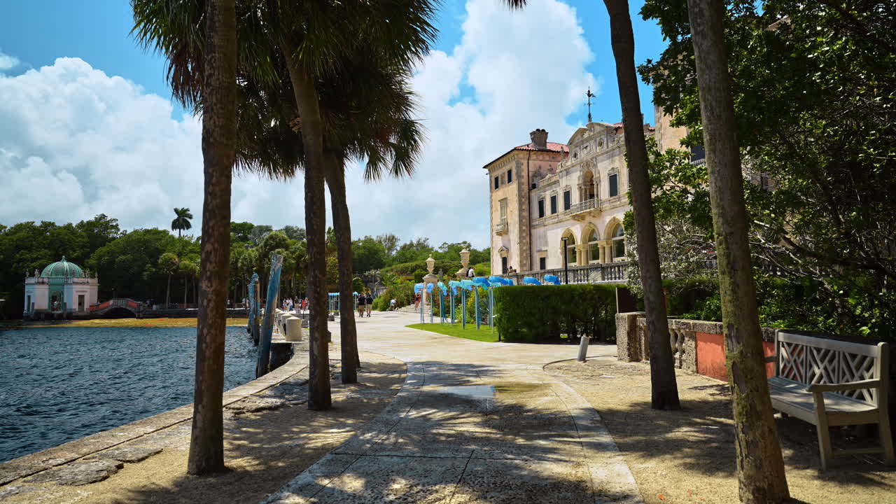 Miami, ABD, 6 Nisan 2026: Miami'deki Vizcaya Müzesi'nde Taş Yürüyüş Yolu ve Bahçeler. Vizcaya Malikanesinde Palmiye Ağaçları ve Tarihi Taş Villa Mimarisi ile Su Boyunca Uzanan Manzaralı Yol.