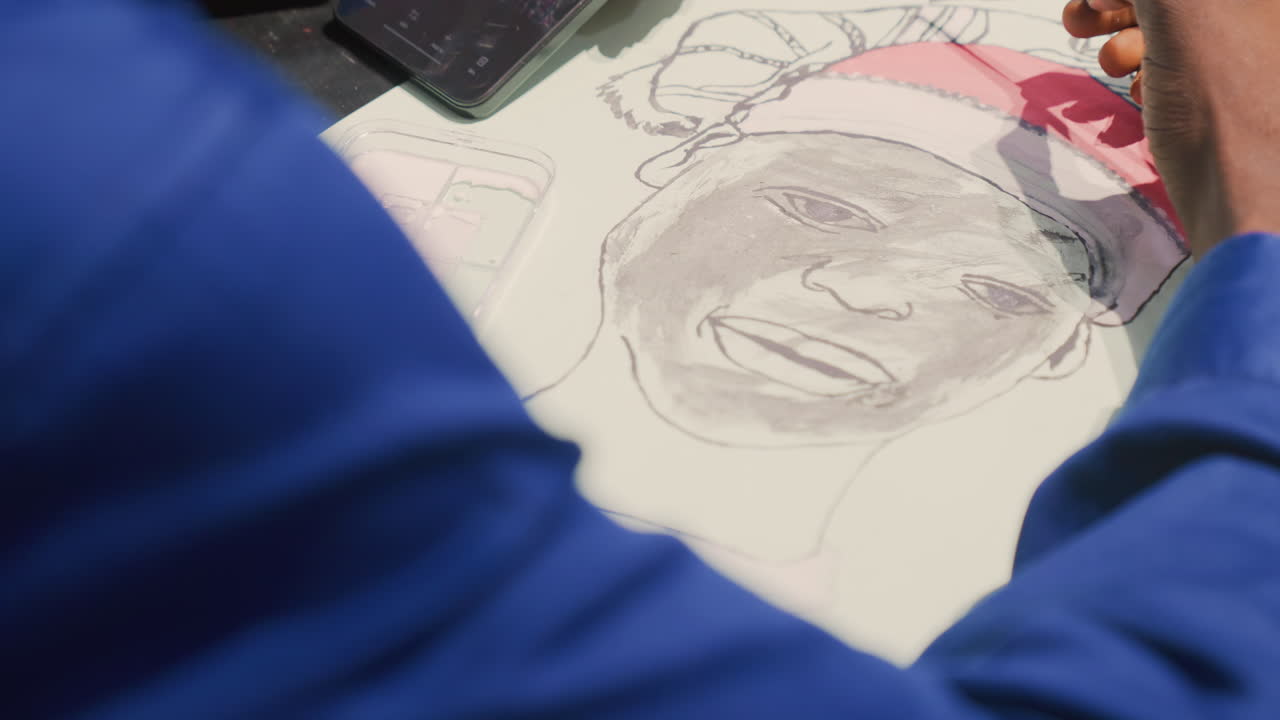 Seniman kulit hitam membuat sketsa lukisan potret di studio, tangan fokus menggunakan pensil hijau untuk mewarnai pria kulit hitam yang tersenyum di atas kertas putih, ponsel pintar di dekatnya, garis grafit detail, suasana hangat yang diterangi lampu.