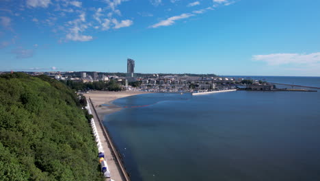 panoramiczne ujęcie z lotu ptaka gdyni z wieżą i pięknym morzem bałtyckim z piaszczystą plażą podczas błękitnego nieba i światła słonecznego - polska, europa