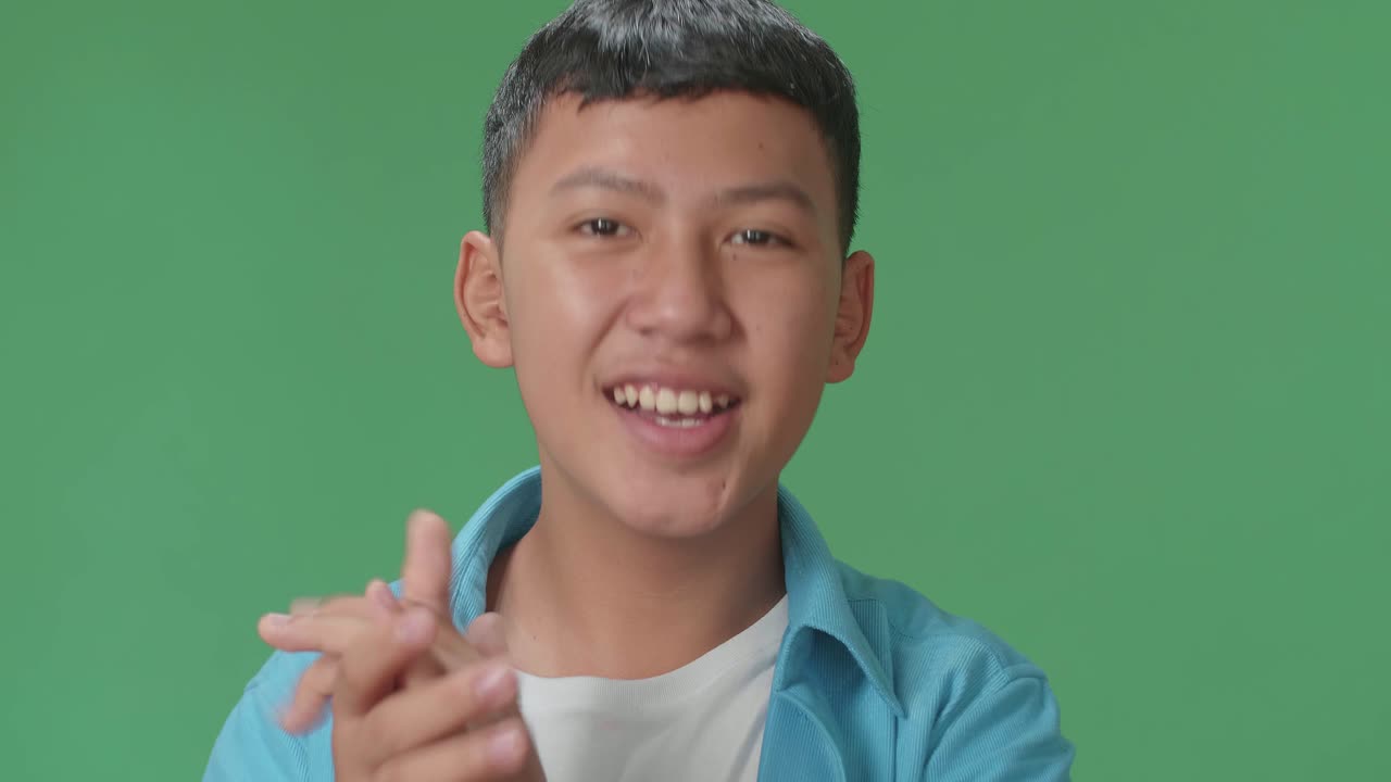 Young Asian Boy Clapping Her Hands In The Green Screen Studio
