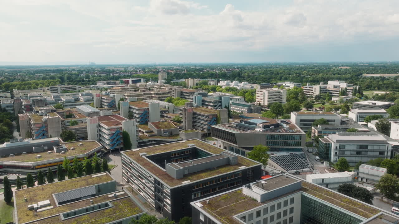 Drone pulling back diagonally with tilt-down revealing Bahnstadt’s inner courtyards and green roofs
