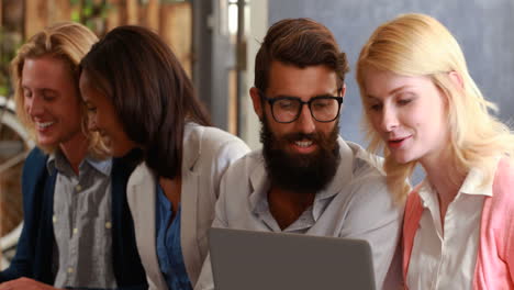 hipster friends talking and using laptop