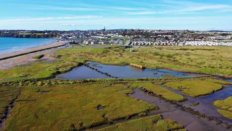 Aerial-Dolly-In-Richtung-Tramore,-Irland-Mit-Blauem-Himmel-Am-Morgen