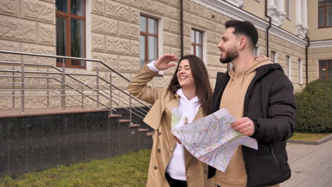 una pareja caucásica chequeando el mapa para obtener direcciones en la calle.