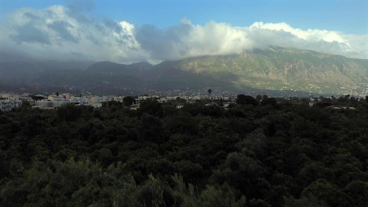 Aerial , fast raise up take off drone footage, revealing east suburbs of Kalamata on a cloudy spring afternoon, flying over an olive grove 4K
