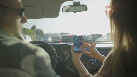 Couple using smartphone in car