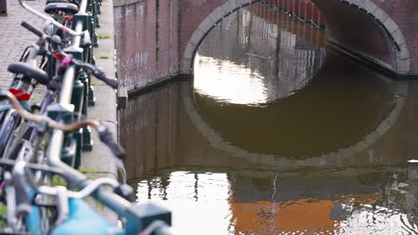 bikes parked by the canal in amsterdam, netherlands