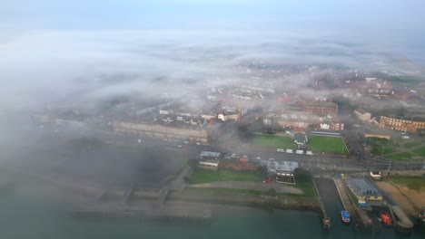 la ciudad de capeland envuelta en niebla con una retirada que revela el estuario del río en niebla en una mañana de verano en fleetwood, lancashire, reino unido