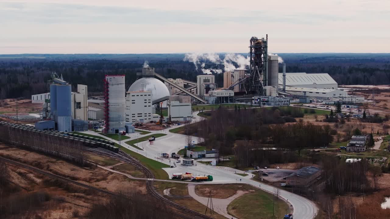 Large cement facility operating in Latvia on cloudy spring day, drone, 4K