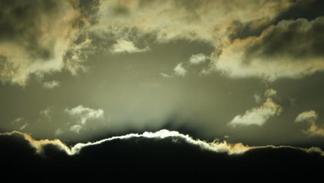 Cielo-Con-Nubes-De-Lluvia-Oscuras-Con-Un-Contorno-Plateado-Y-Dorado-Que-Oscurece-El-Sol---Movimiento-Hipnótico-Lento